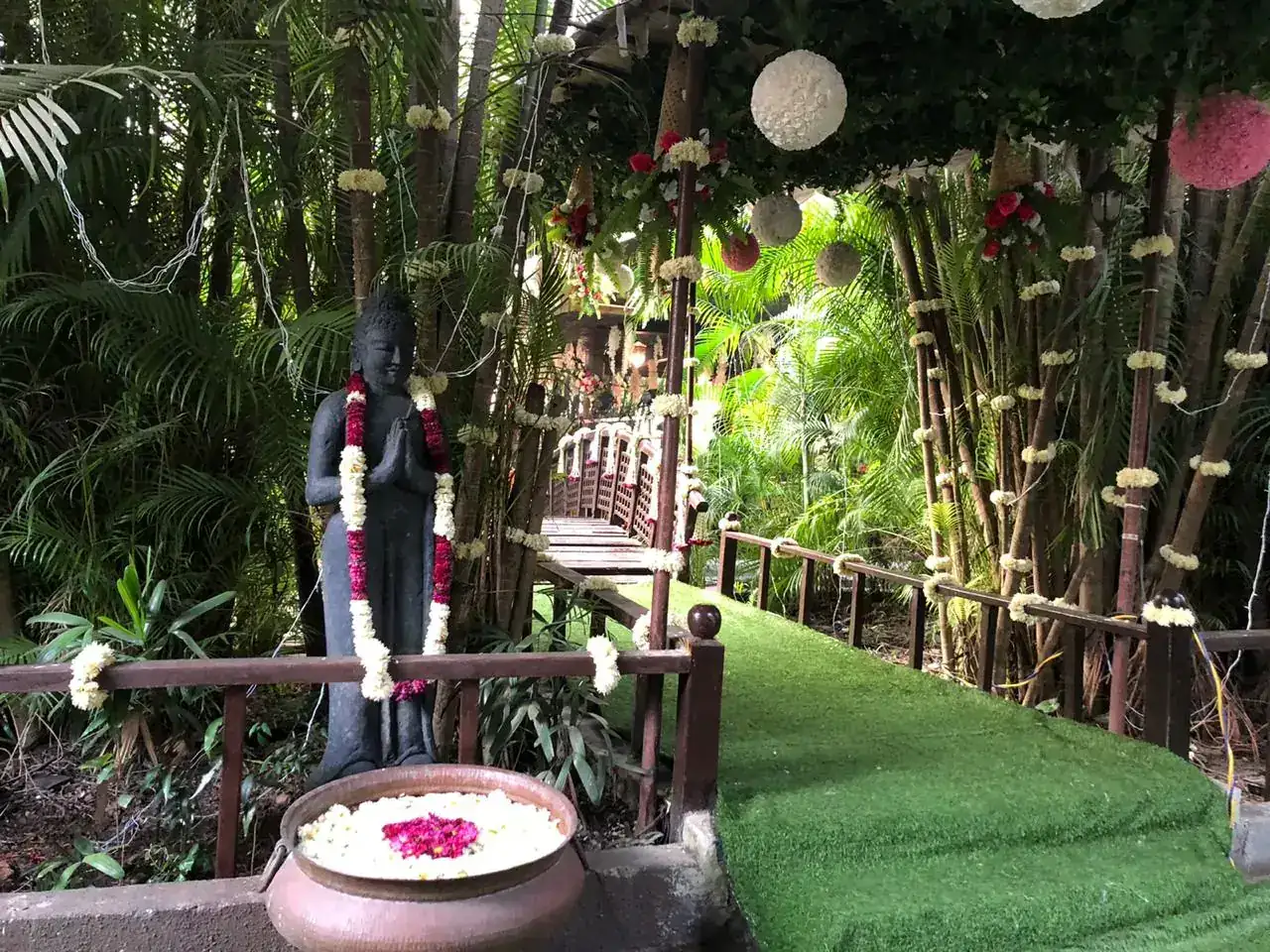 Bamboo garden with statue and floral bowls at Exotica