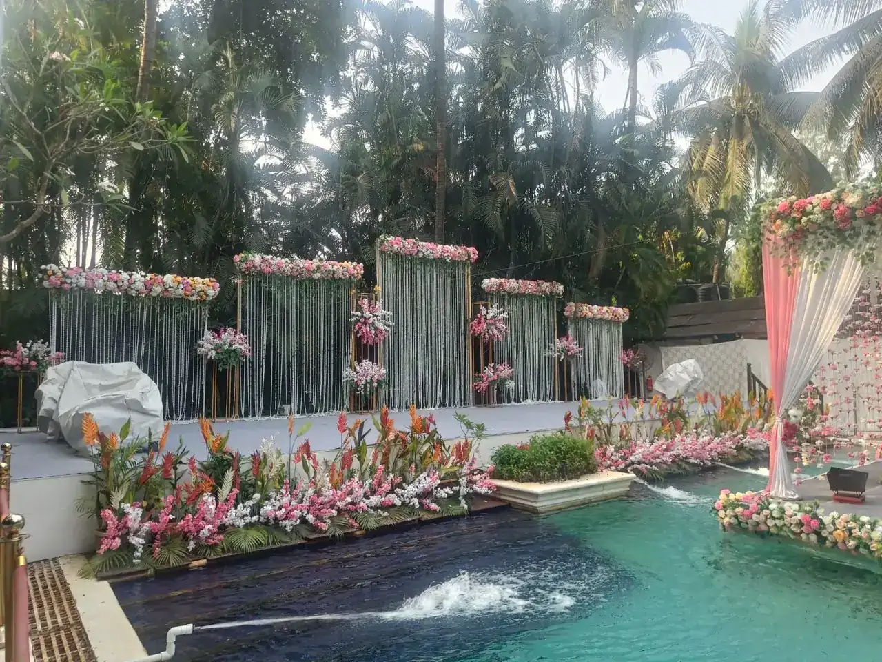 Poolside wedding setting decorated with pink flowers at Exotica, Thane