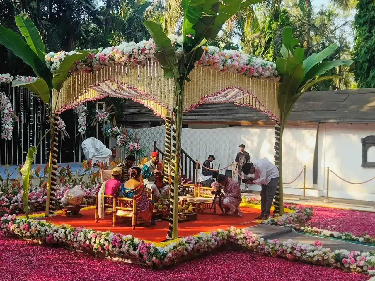 Wedding ritual under a floral canopy mandap on petal-covered lawns at Exotica